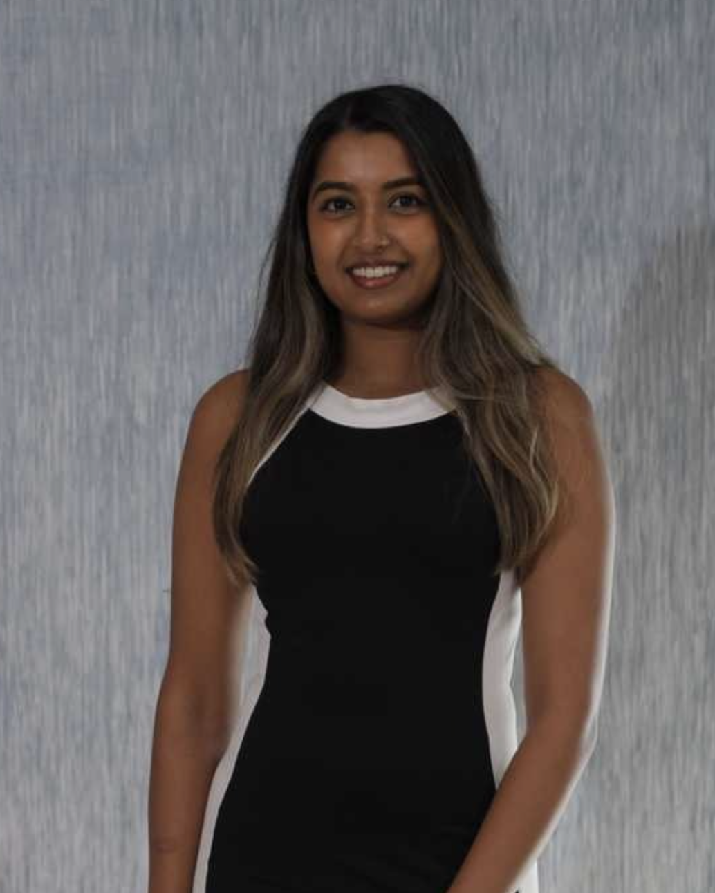 Disha, writer at Marketing Star, headshot with long dark hair, black and white sleeveless dress, smiling