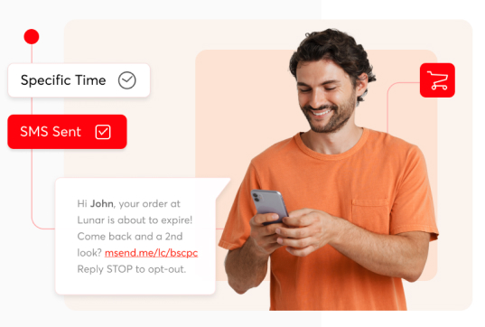 Smiling man in orange shirt reading SMS on phone with order reminder message, representing targeted SMS marketing
